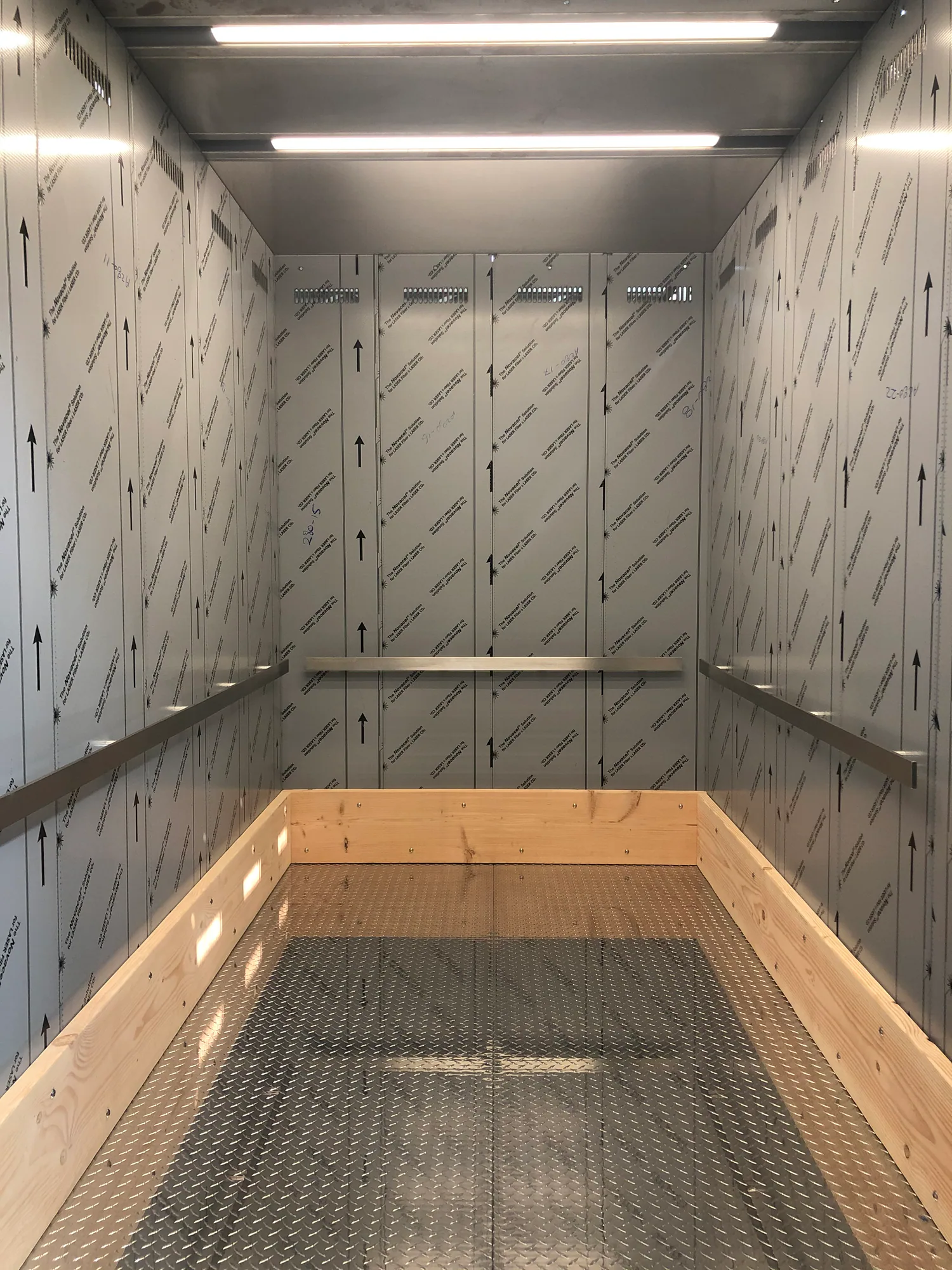 Freight elevator interior at 1900 Western with stainless panels and protective wood rails