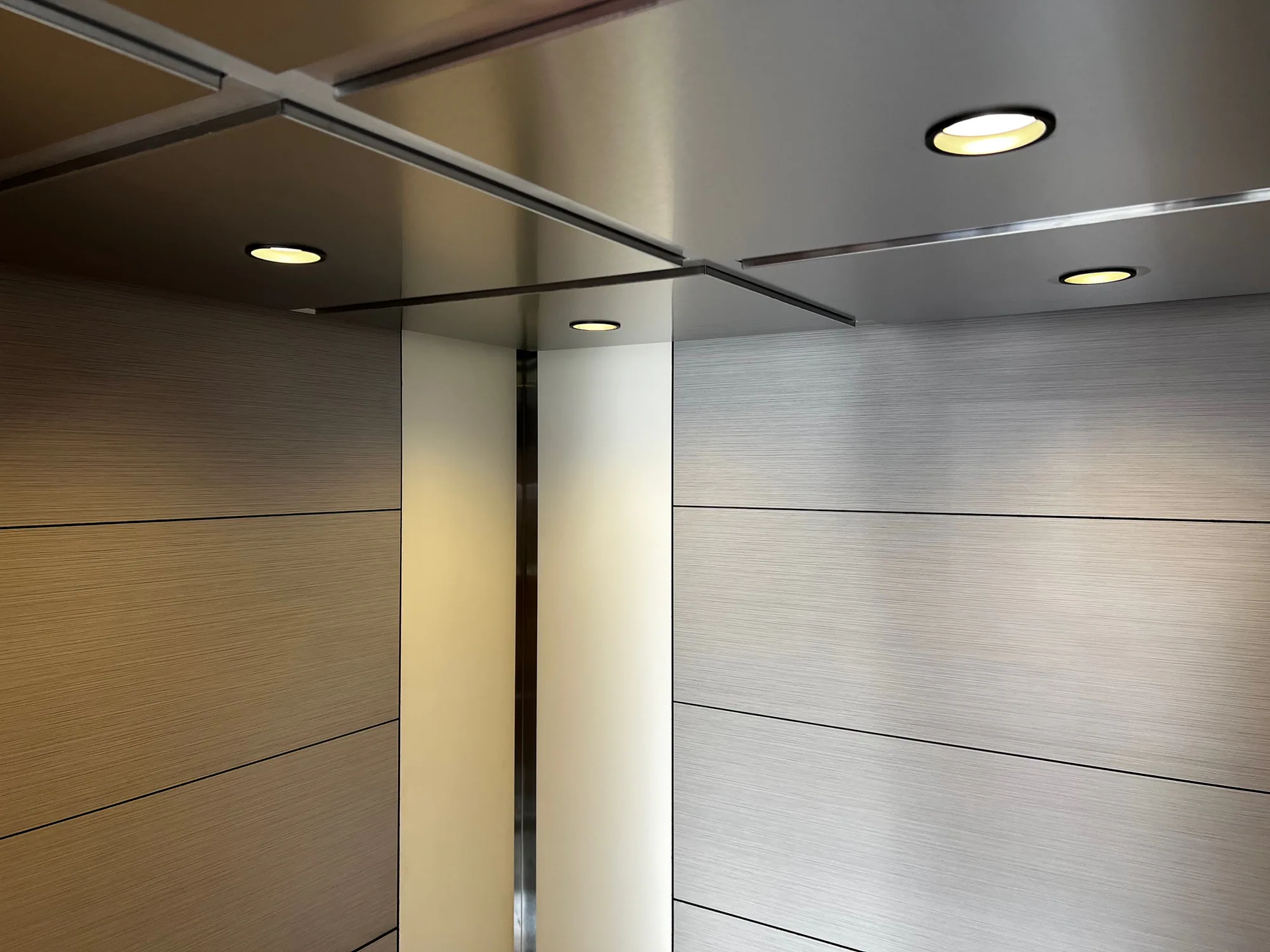 Elevator interior at Kankakee College with light wall panels and dark trim