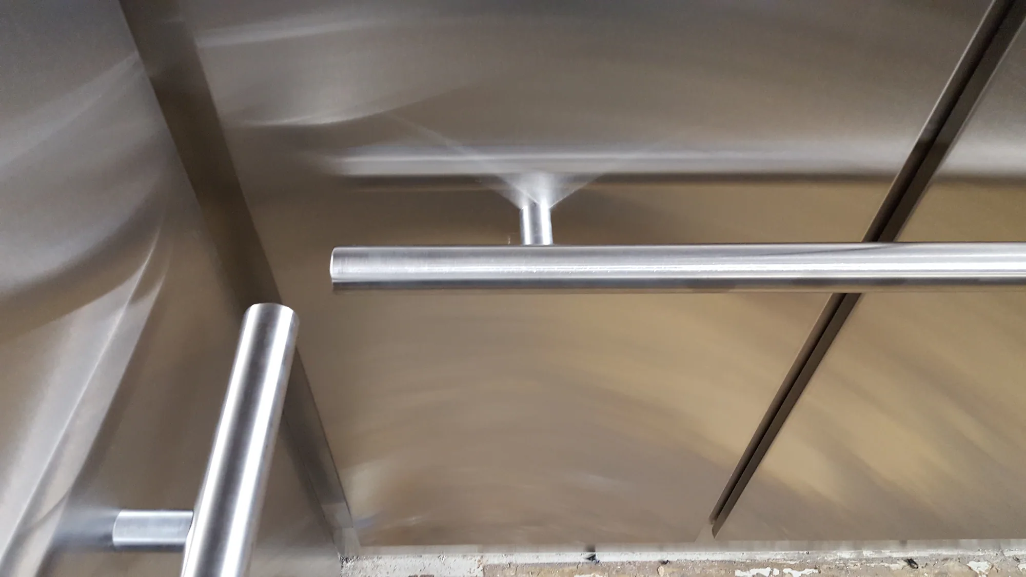 Stainless elevator handrails arranged across metal wall panels