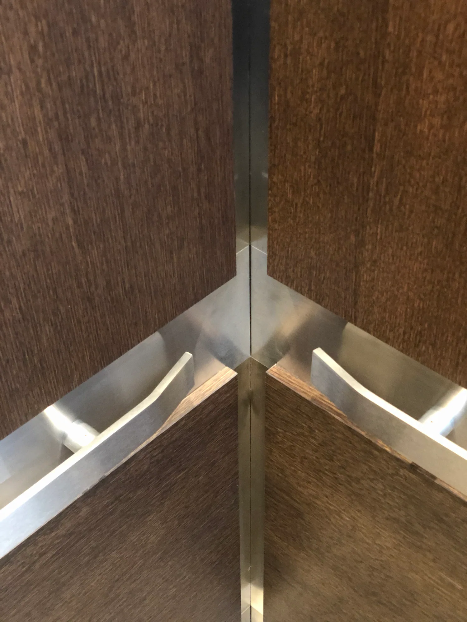 Stainless elevator handrails meeting at a mitered interior corner
