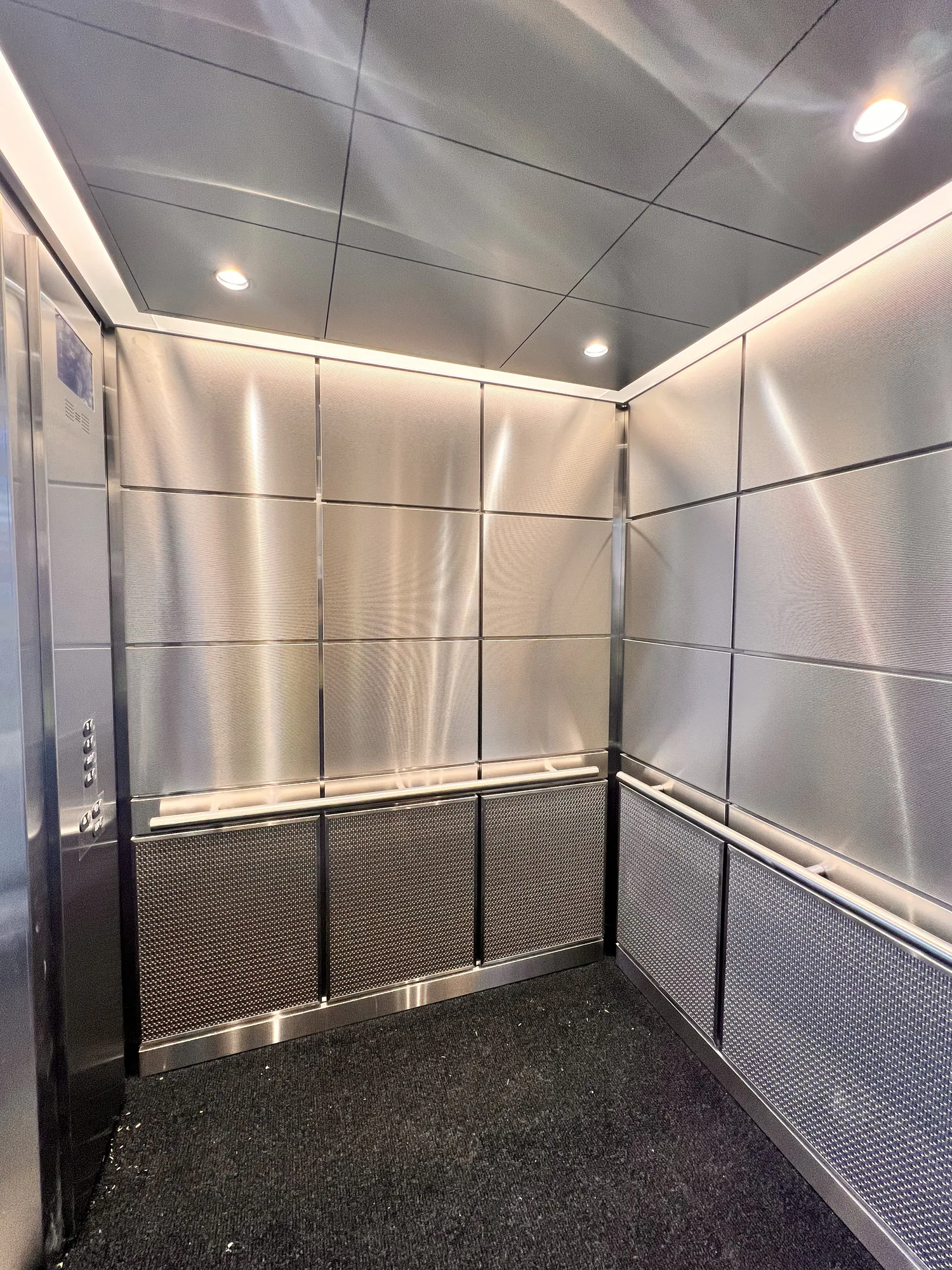 Northwestern hospital elevator cab with bright stainless wall panels and handrails