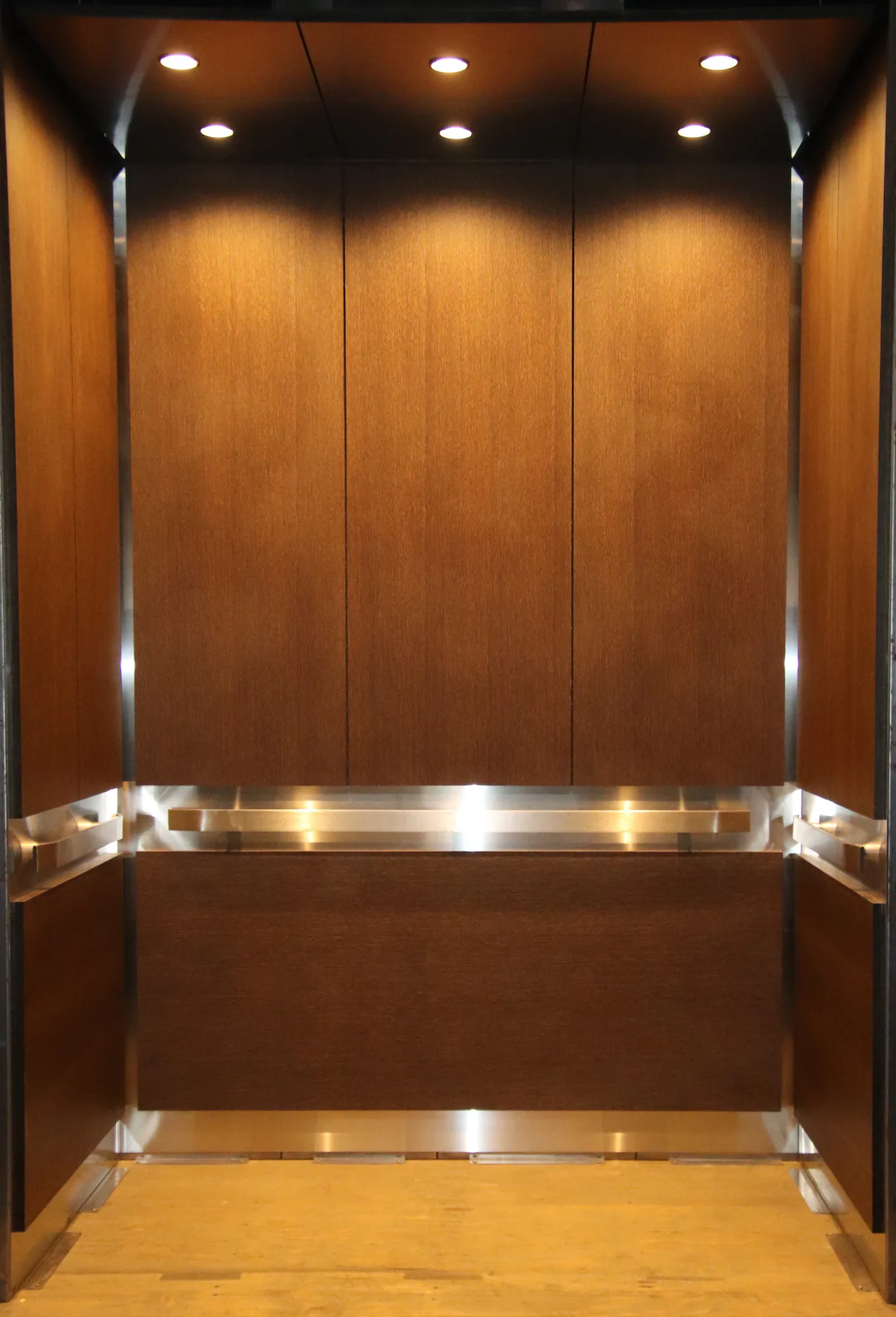 Warm woodgrain Hyde Park elevator interior with polished handrails