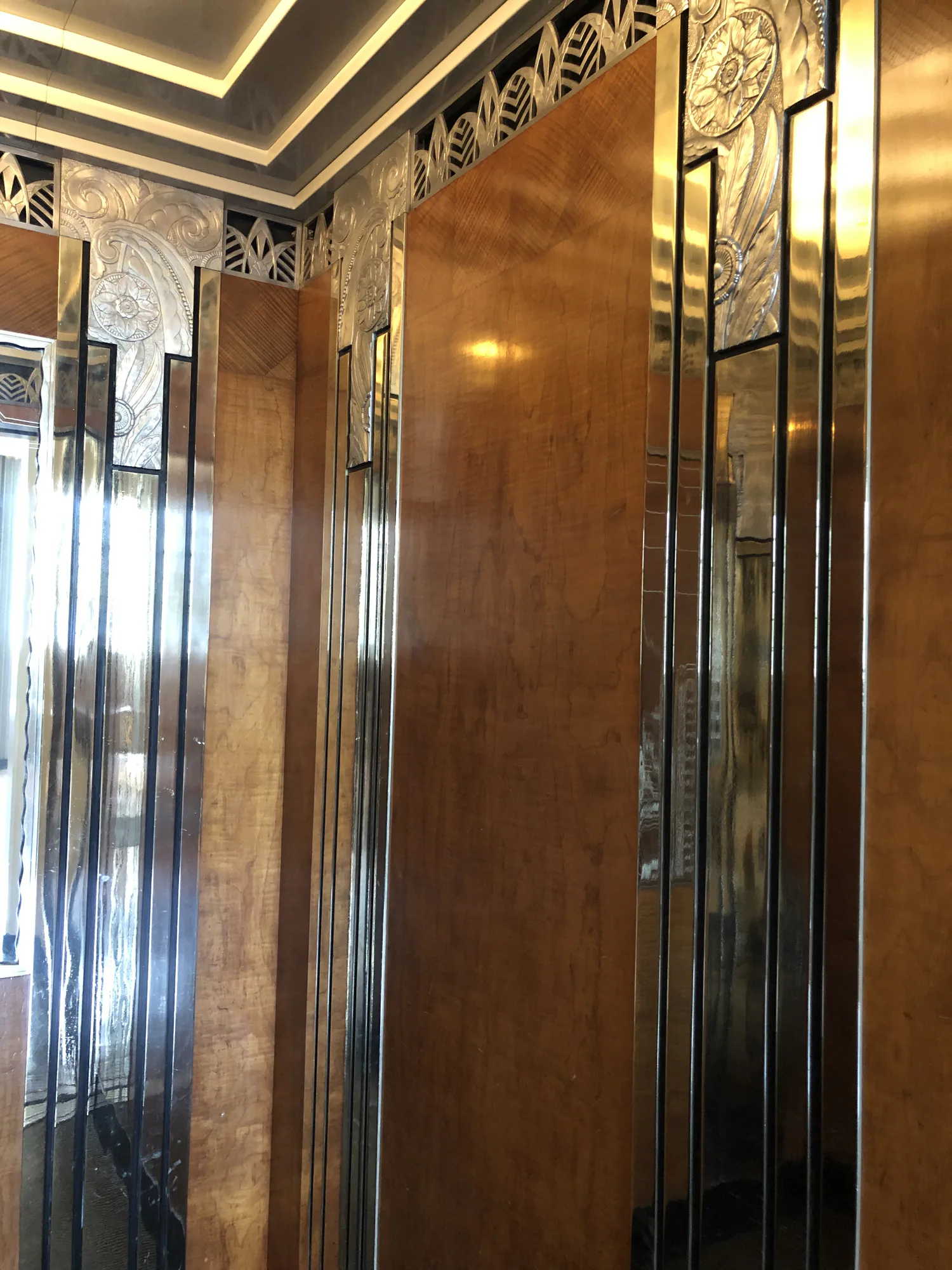 Decorative bronze elevator cab corner with mirror panels and detailed trim