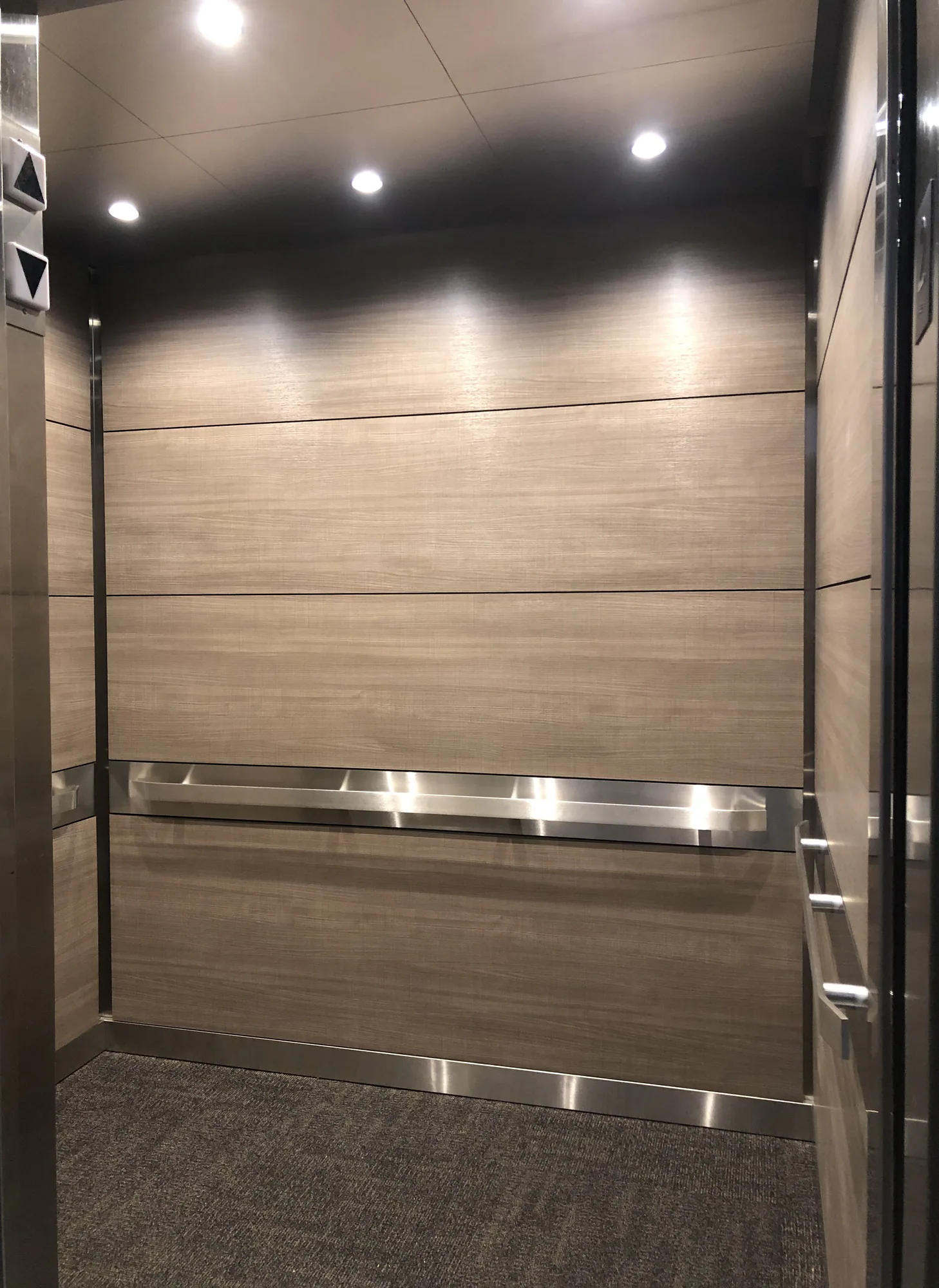 Kane County elevator interior with wood-look panels and stainless rails
