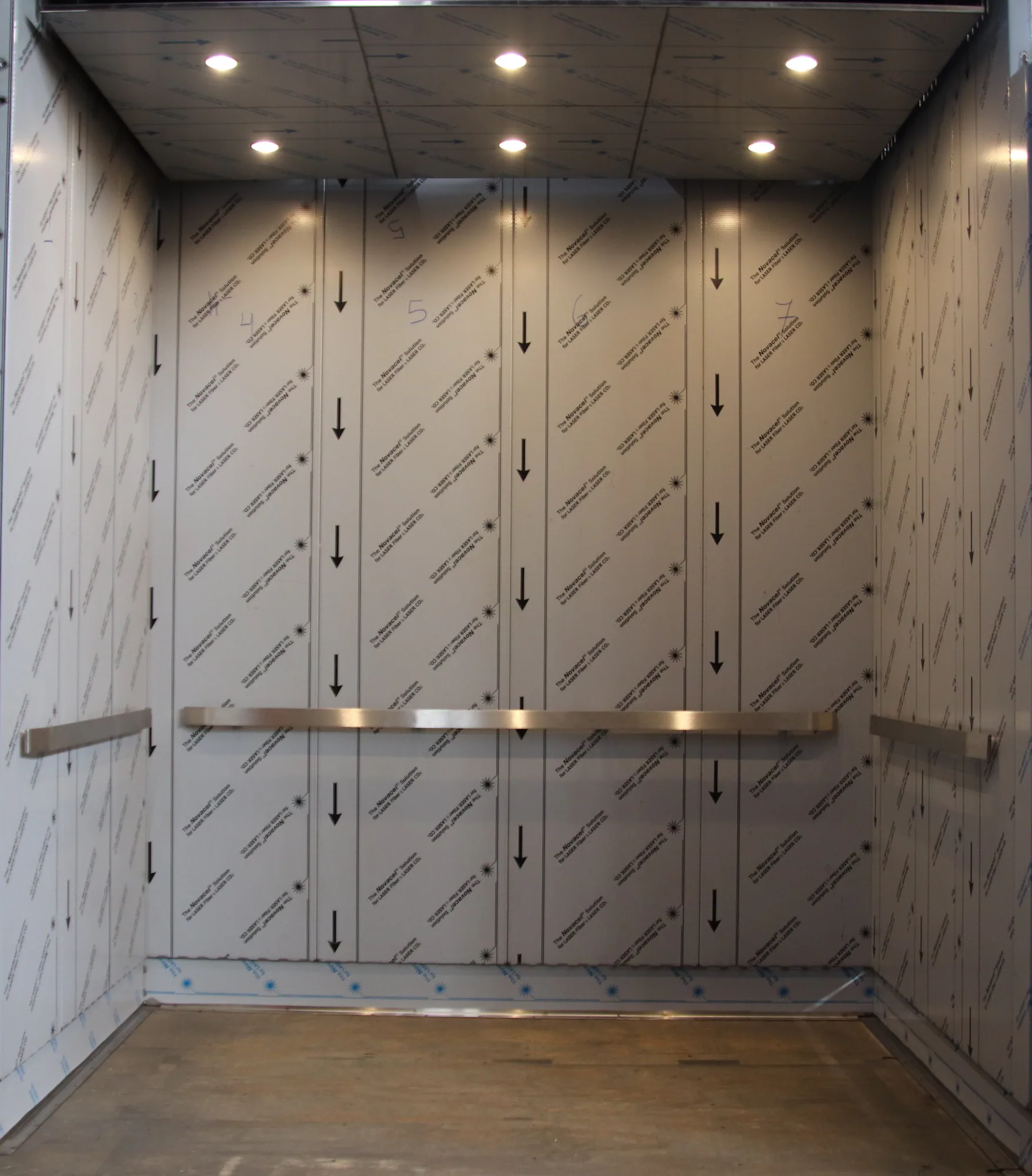 Chicago Amtrak elevator cab with patterned stainless wall panels and dark ceiling