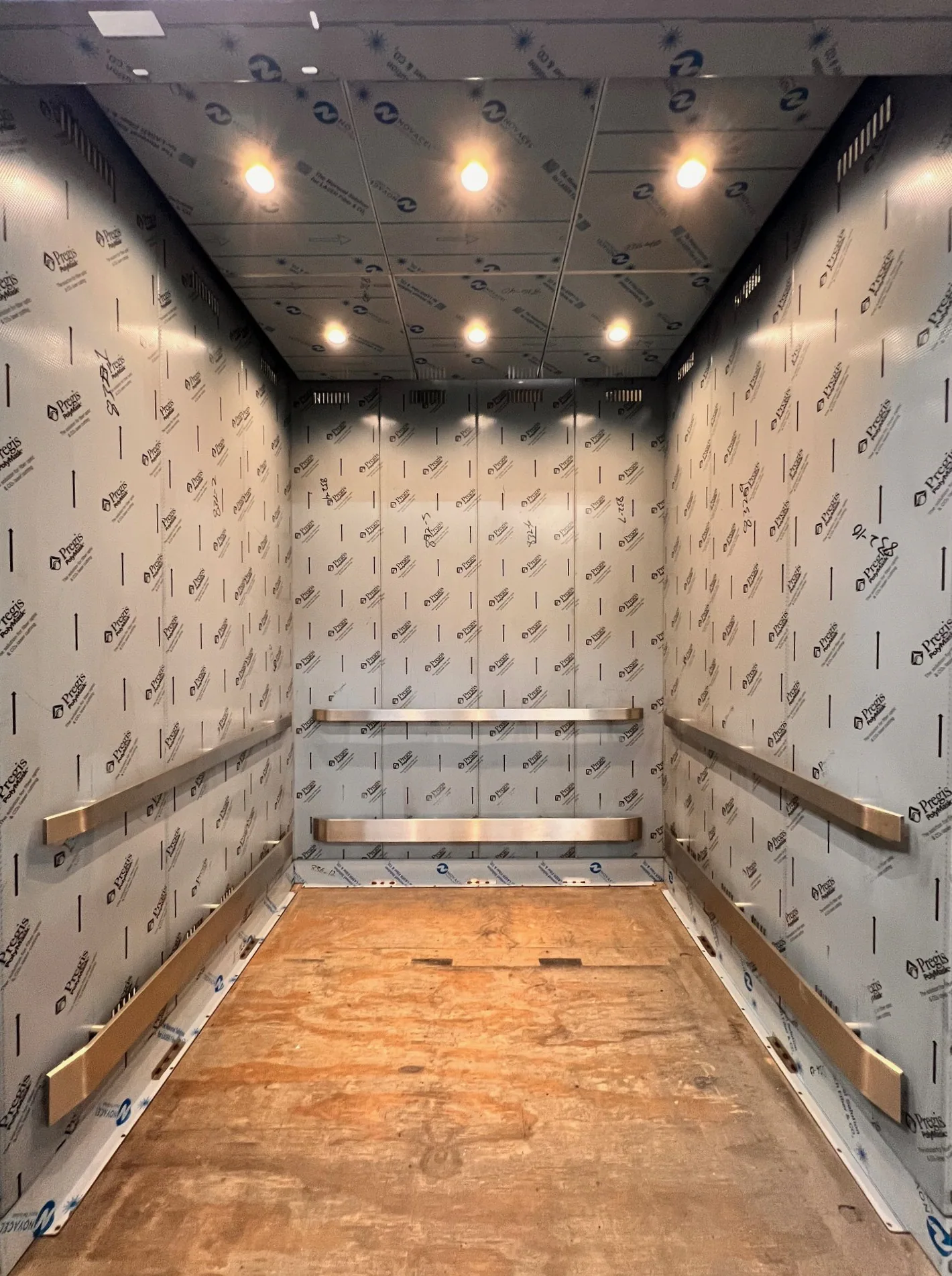 Chicago transit elevator cab with patterned wall protection and recessed lighting