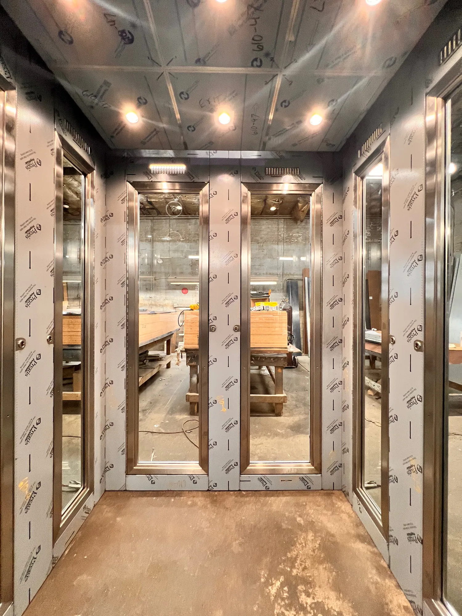CTA elevator cab in Chicago with patterned stainless walls and exposed structural detailing