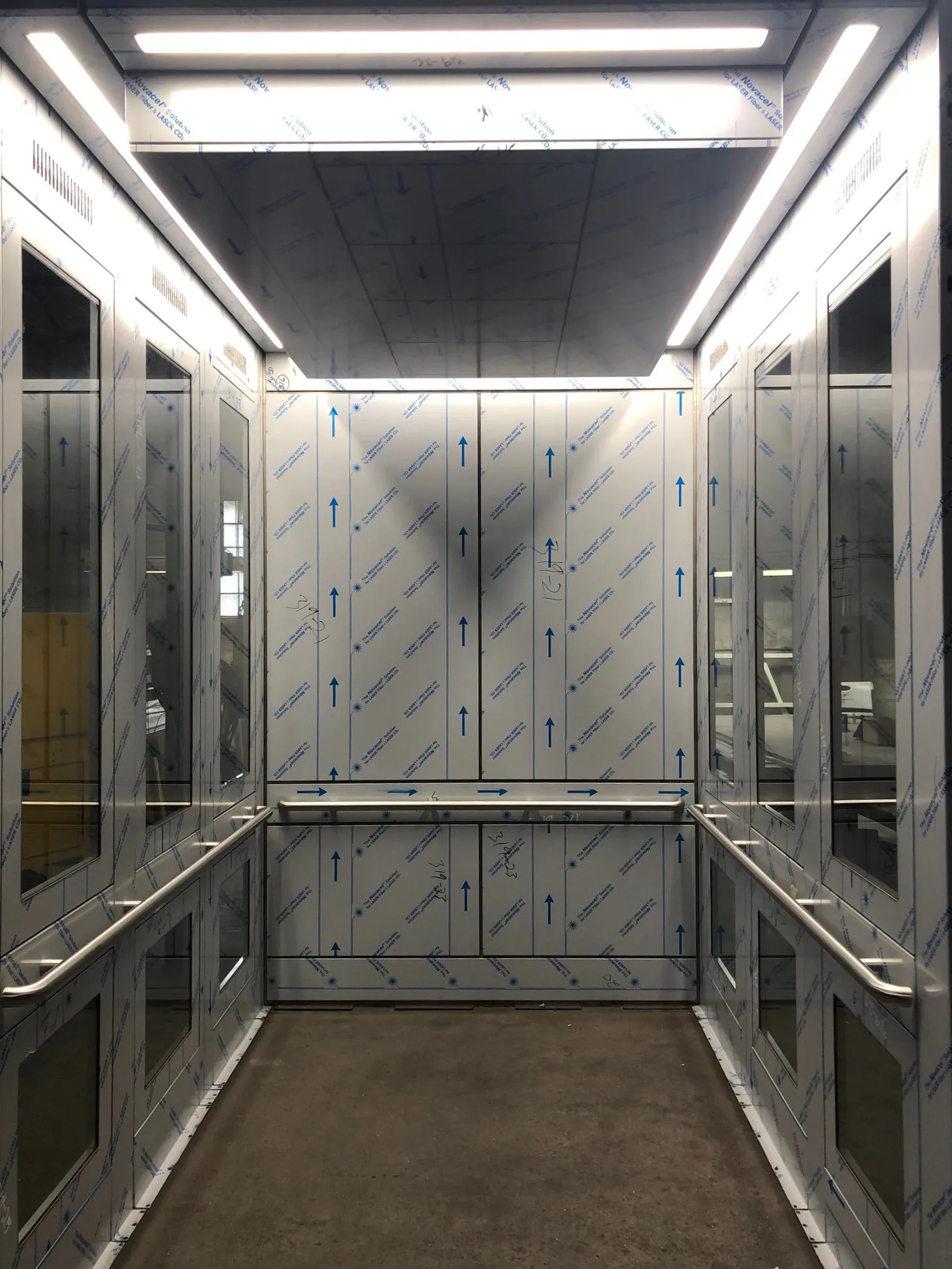 MLT Seattle transit elevator cab with bright stainless panels and dark rails