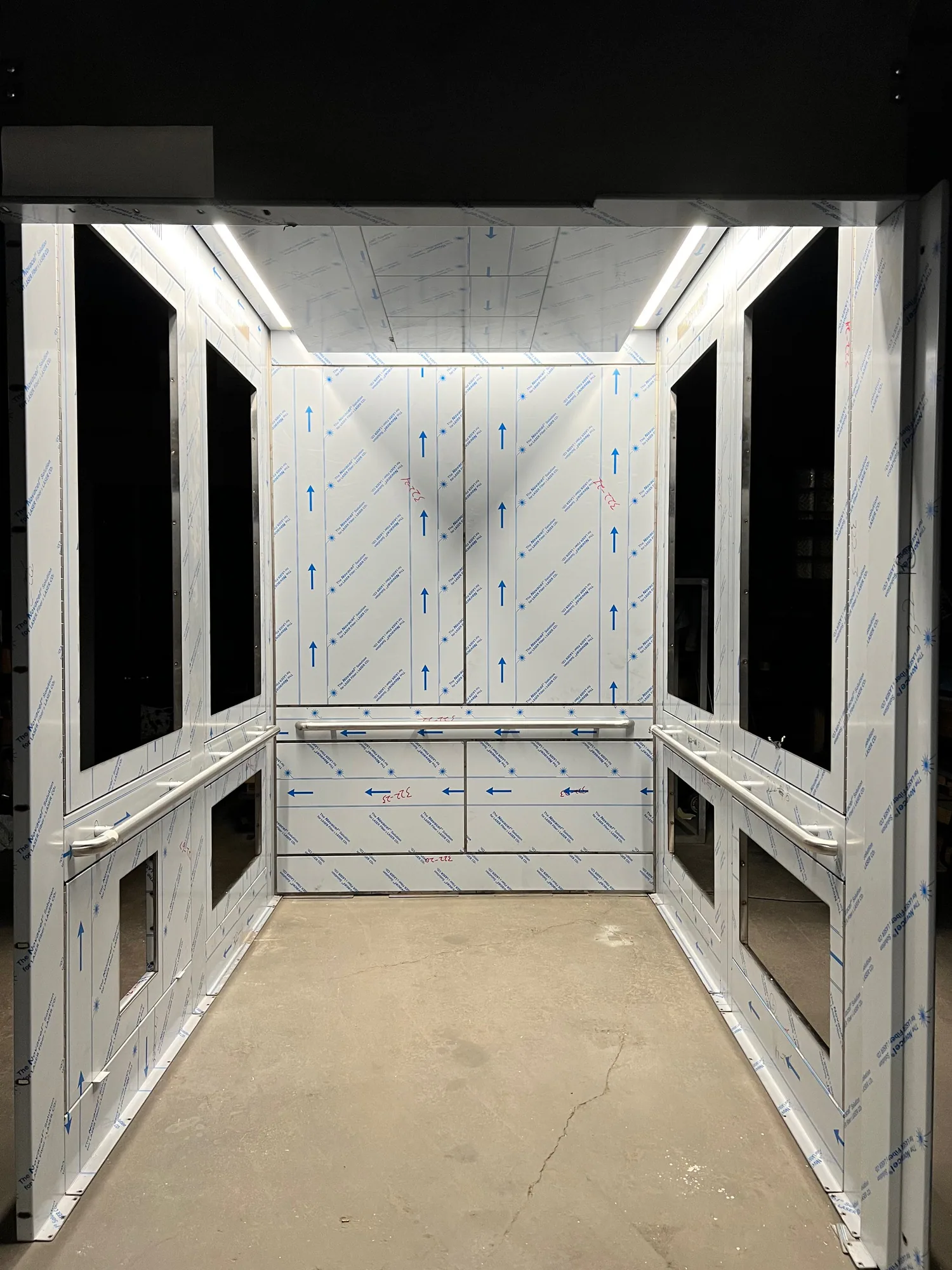 MLT Seattle elevator interior with geometric wall panels and contrasting metal rails